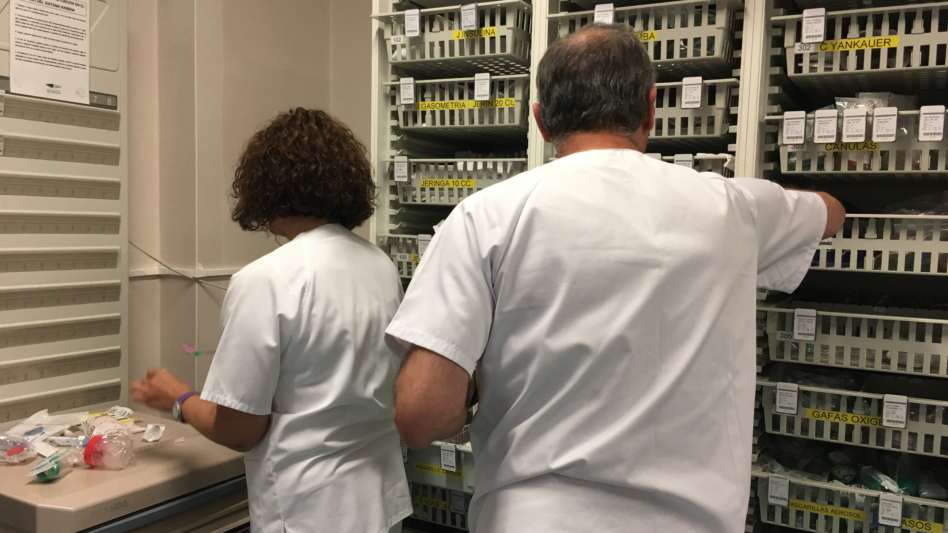 Dos enfermeros preparan la medicación para un paciente. 
